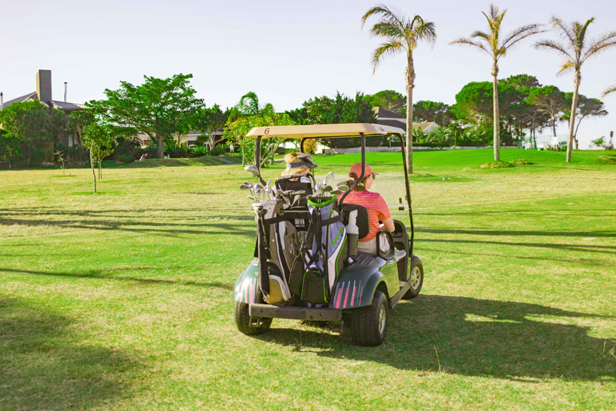 Two people in a golf cart on a course
