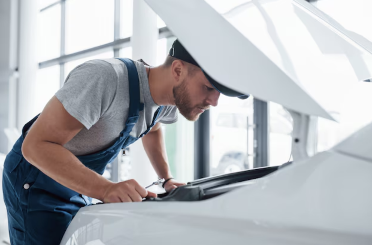 Mechanic inspecting a vehicle’s air conditioning system during a maintenance check